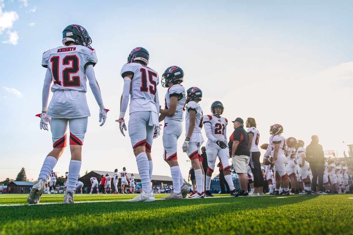 Free A high school football team lines up on the field, ready for their match. Stock Photo