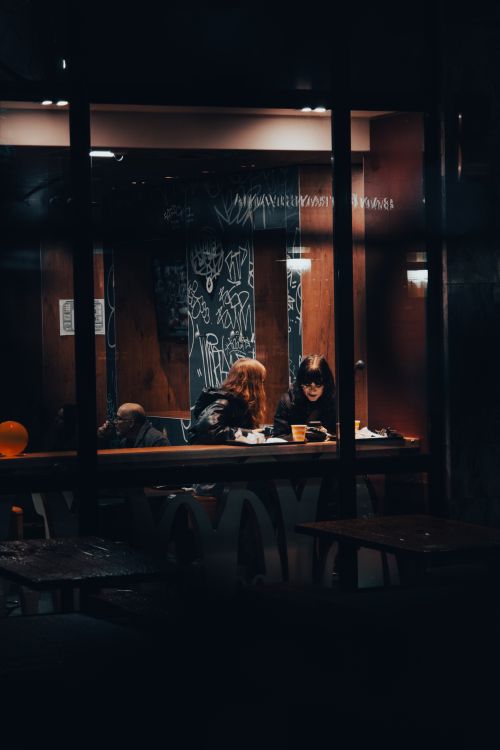 Free A cozy café at night with people enjoying leisure time and coffee. Stock Photo