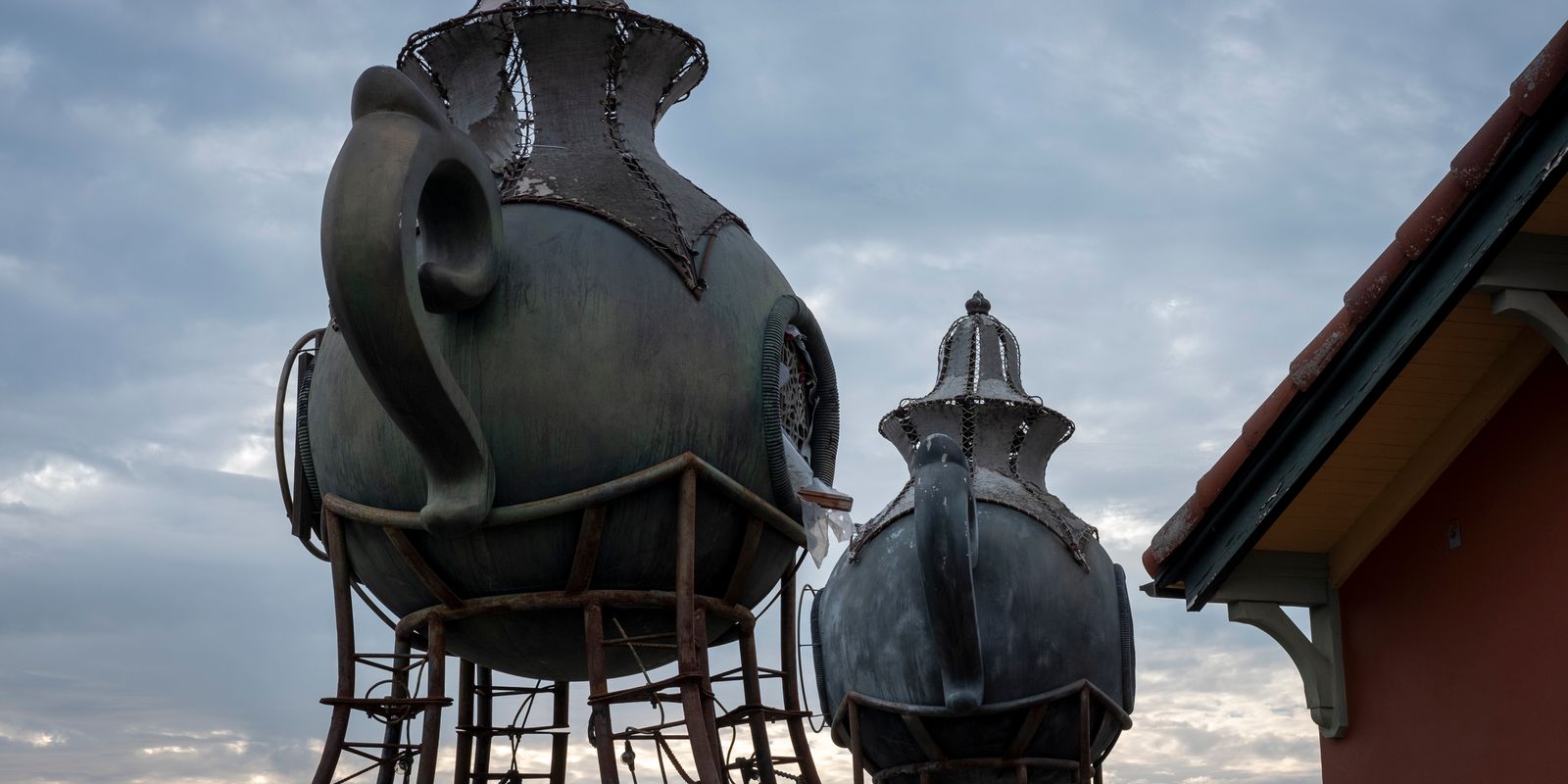 A large decorative metal teapot sculpture on display