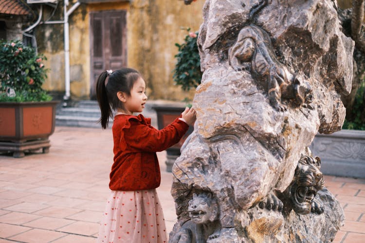 Photograph Of A Child Looking At A Sculpture