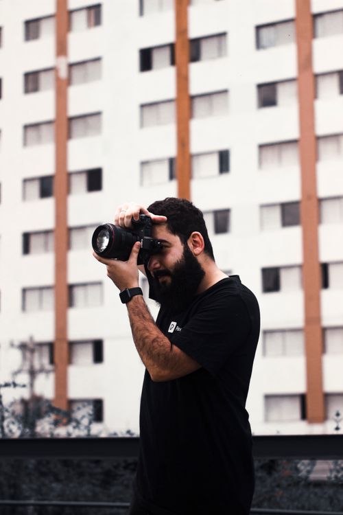 Free Photographer capturing urban scenes outdoors with focus and style. Stock Photo