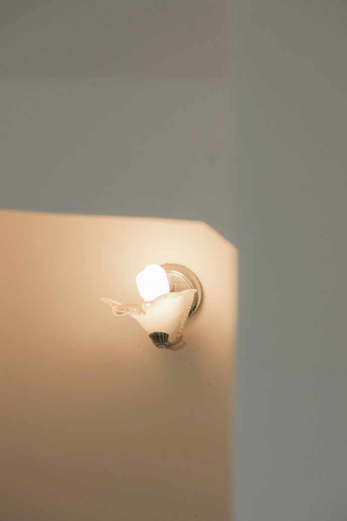 A small sconce casting soft light on a minimal wall — photo by 𝗛&𝗖𝗢 on Pexels