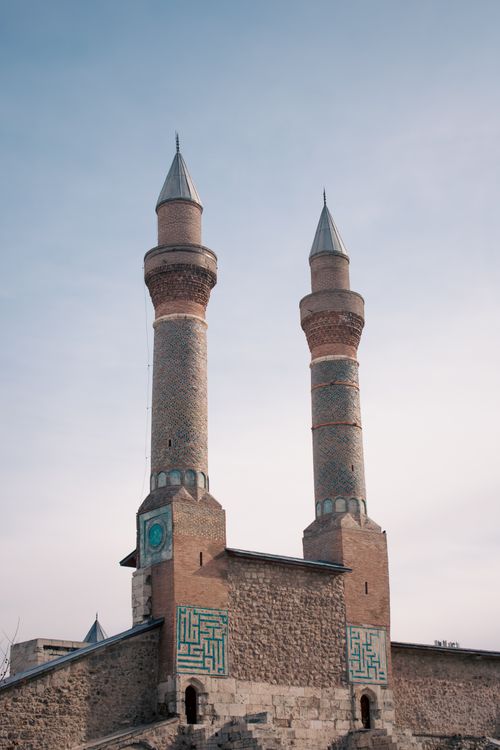 Free A stunning architectural view of dual minarets under a clear blue sky, showcasing intricate stonework. Stock Photo