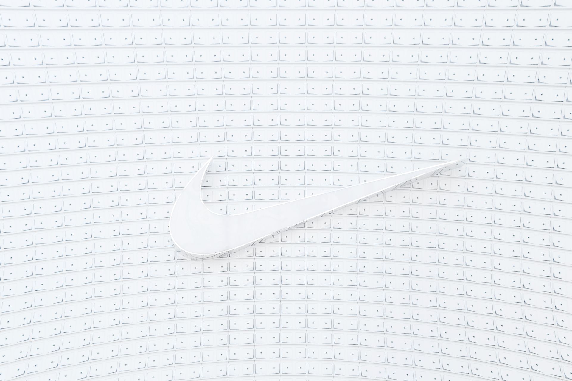 Elegant white logo displayed on a textured, geometric white background with cubes. Ideal for modern design and branding concepts.