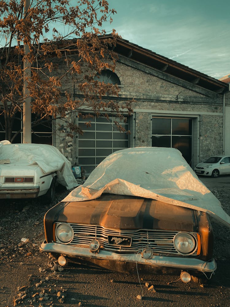 Abandoned Retro Vehicles Covered In Tarpaulin Sheet