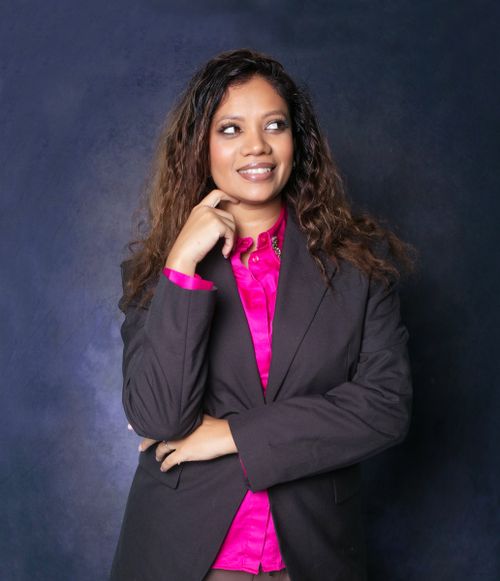 Free Smiling woman in business attire with a vibrant pink shirt, exuding confidence. Stock Photo