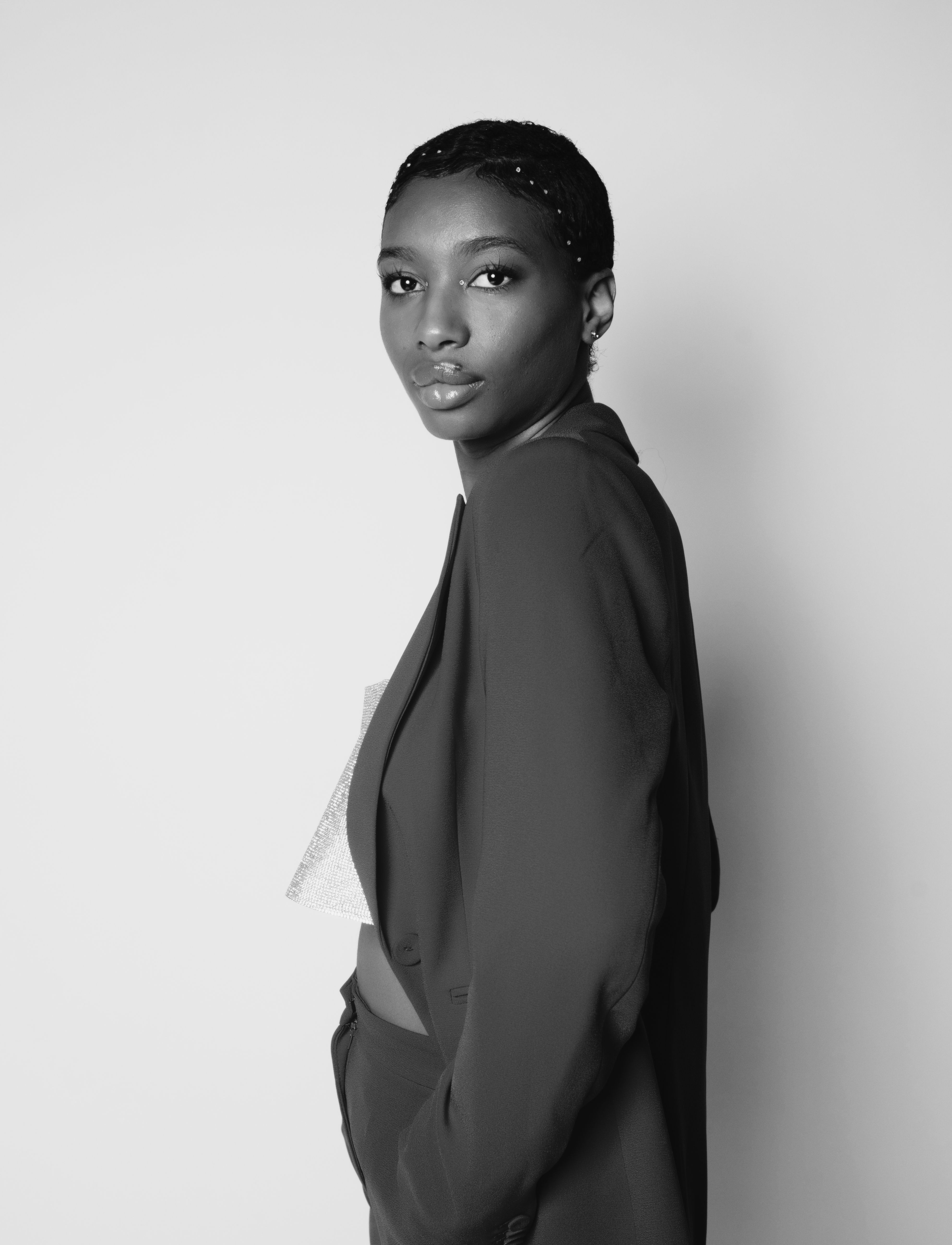 Sophisticated black and white portrait of a woman in a fashionable suit, exuding elegance and confidence.