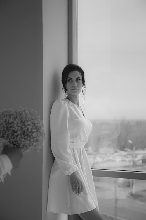 Woman in White Dress Standing in Window