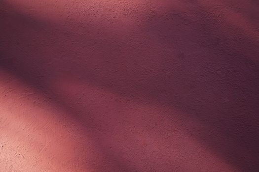 Subtle shadows on a textured wall create an abstract and calming visual.