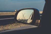 Rental car wing mirror on the coast road — photo by Shukhrat Umarov on Pexels