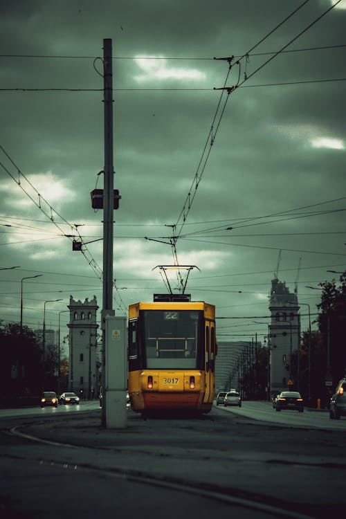 A yellow trolley on a street with power lines