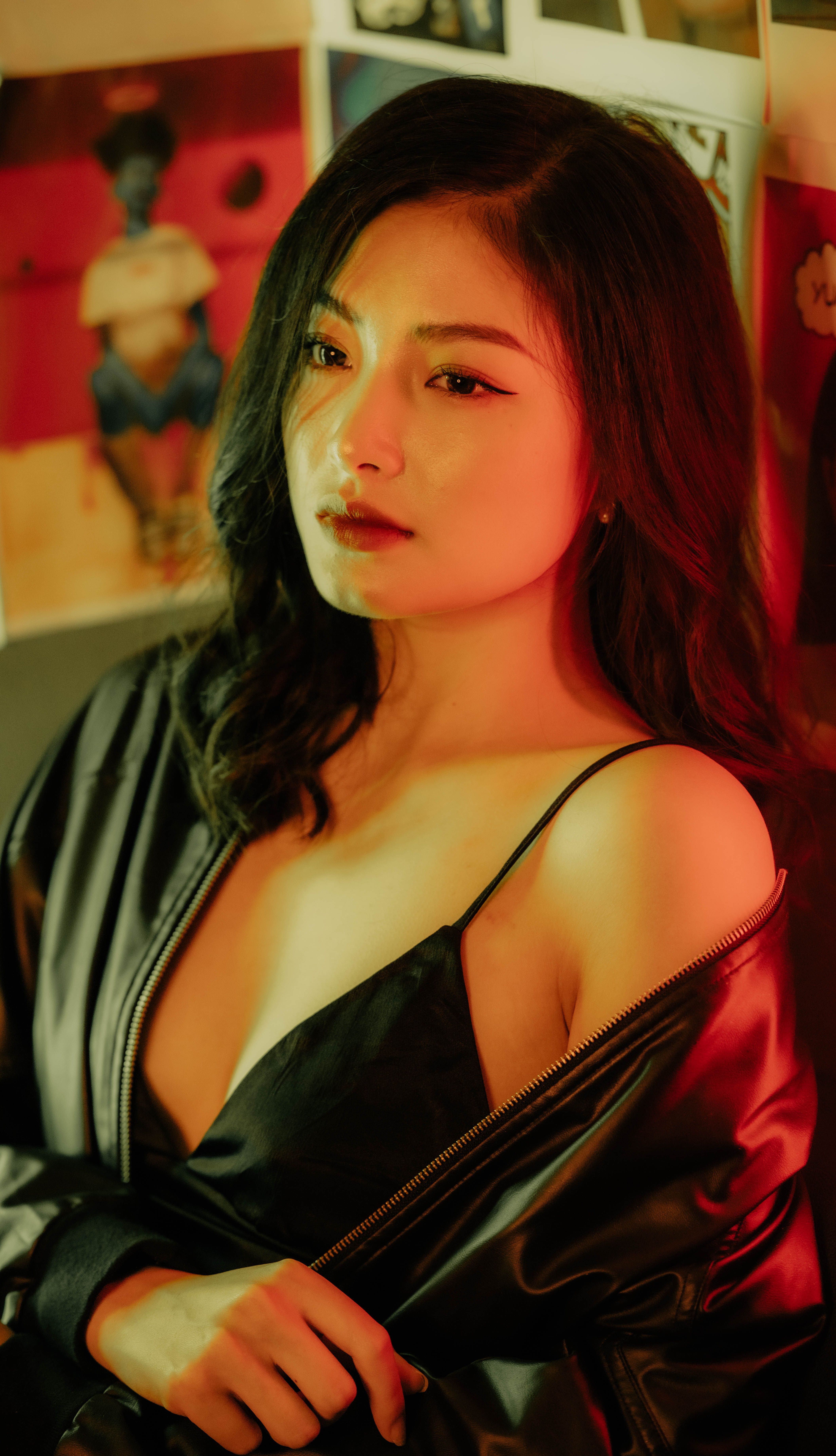 Portrait of a stylish woman in a satin robe against a colorful art wall backdrop.
