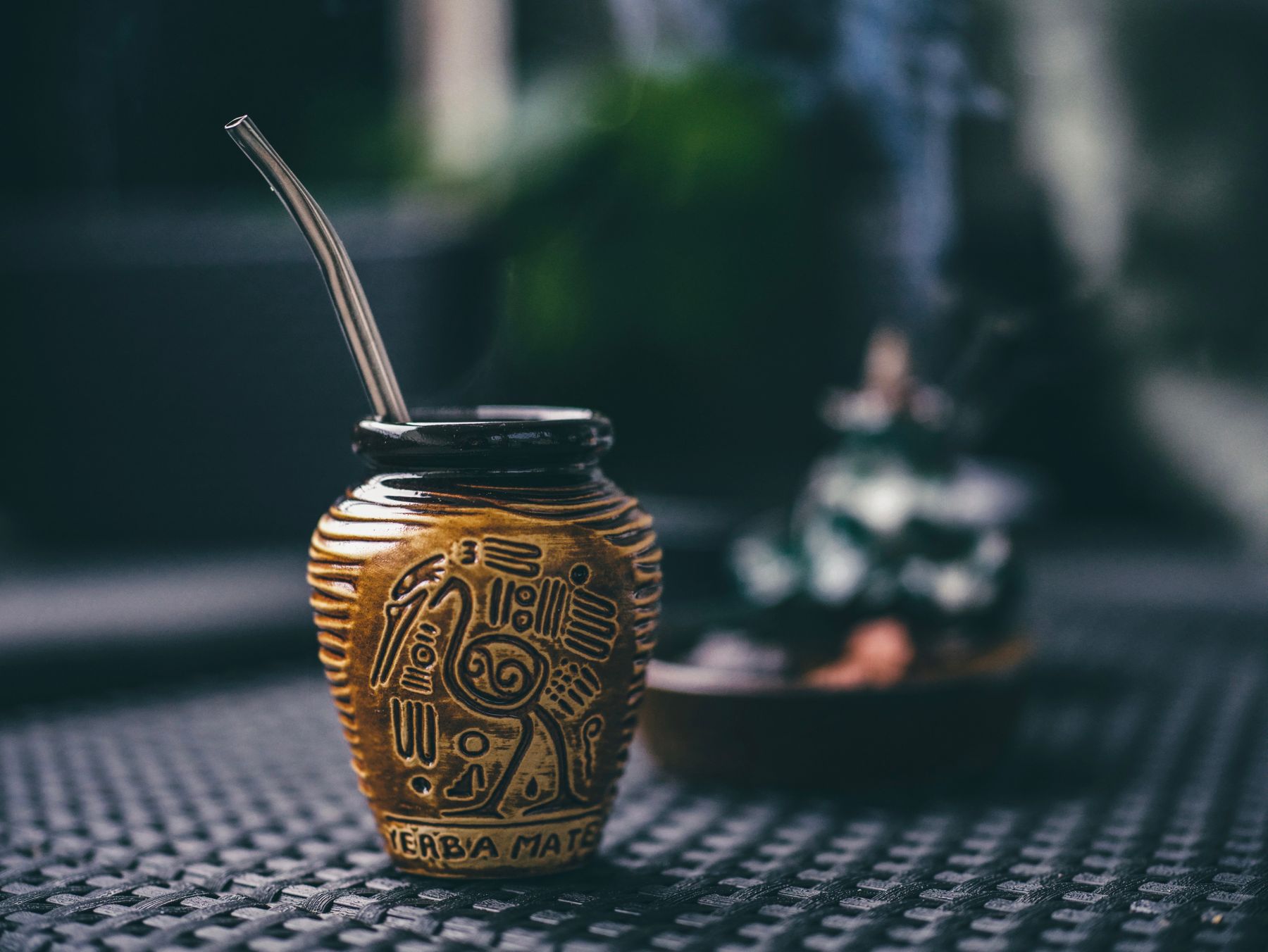 Carved gourd and metal straw resting on a dark table — photo by Egor Komarov on Pexels