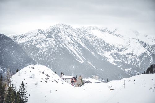 Free A picturesque snowy village nestled in the mountains under overcast skies. Stock Photo