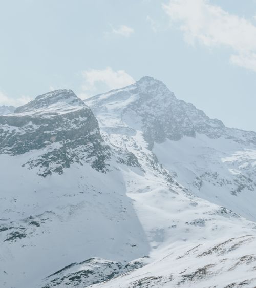 Free A stunning view of snow-covered mountains under a bright blue sky, perfect for winter enthusiasts. Stock Photo
