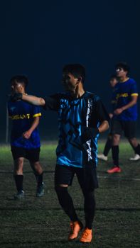 Soccer players in sportswear on the field during a night match.