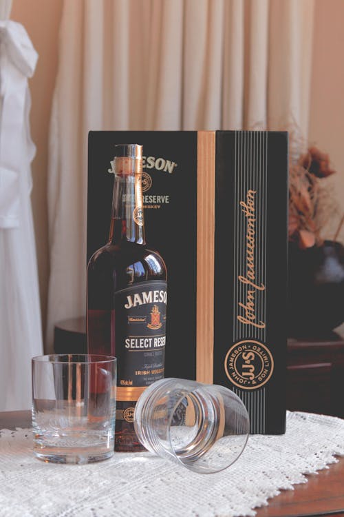 Free Jameson Select Bottle Near Clear Glass Drinking Cups and Box Stock Photo