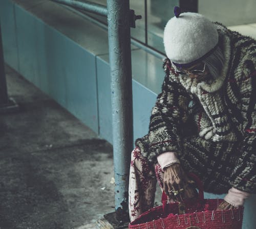 Cappello Bianco Da Portare Della Donna Che Si Siede Sulla Sporgenza