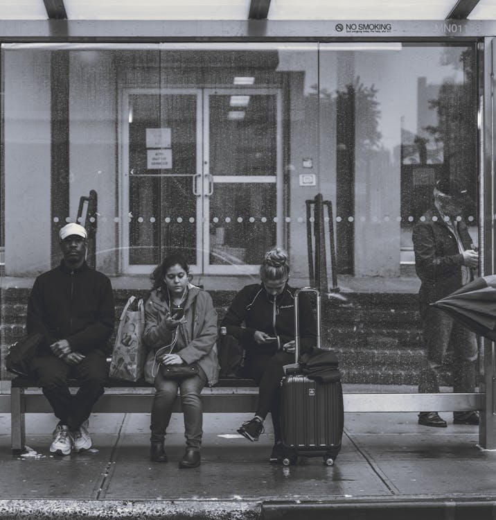 Personas Sentadas En Un Banco En Una Parada De Autobús