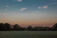黄昏时分，宁静的乡村月出地平线，绿树成荫