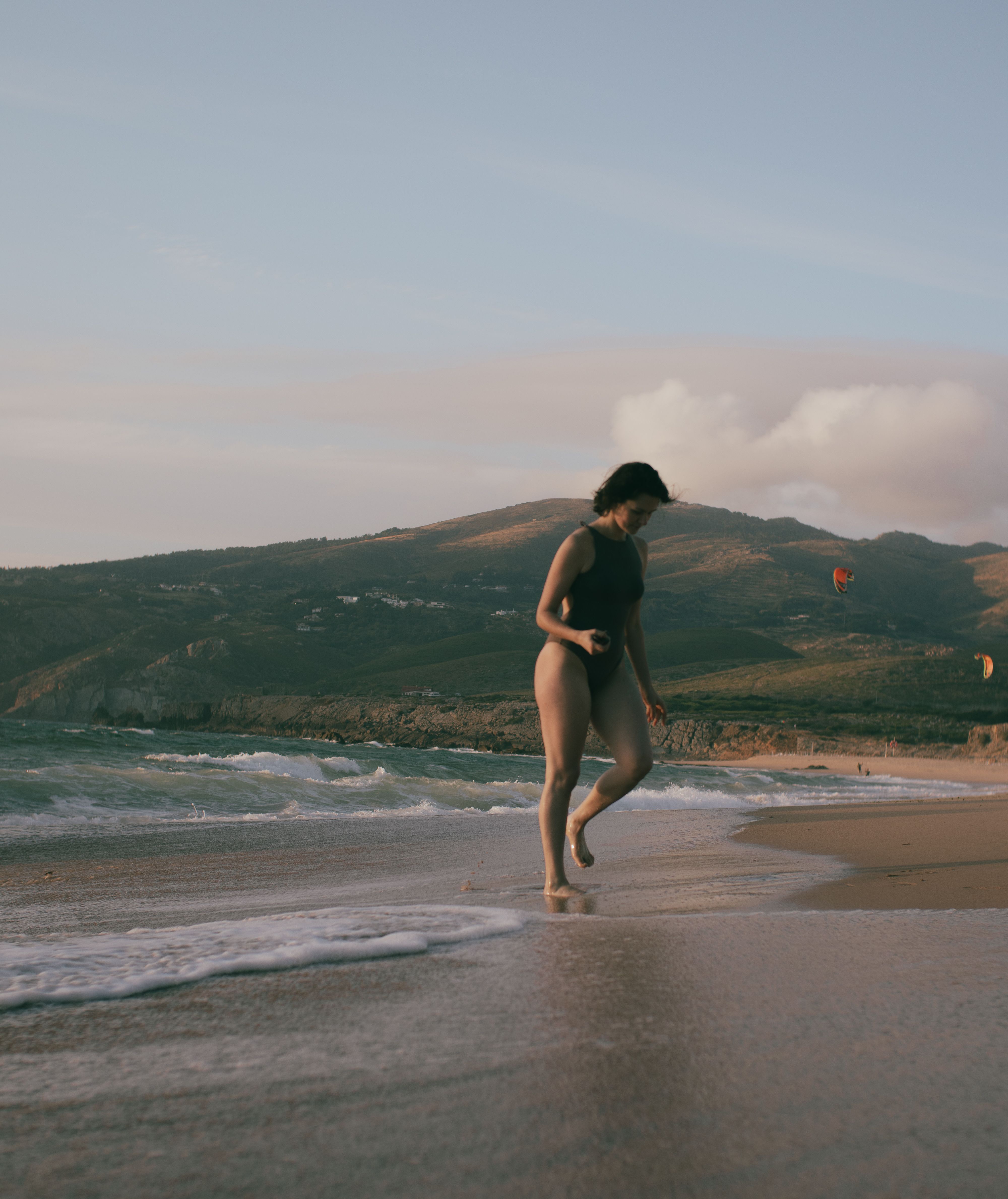 A Woman in Black Swimsuit Walking on the Beach · Free Stock Photo