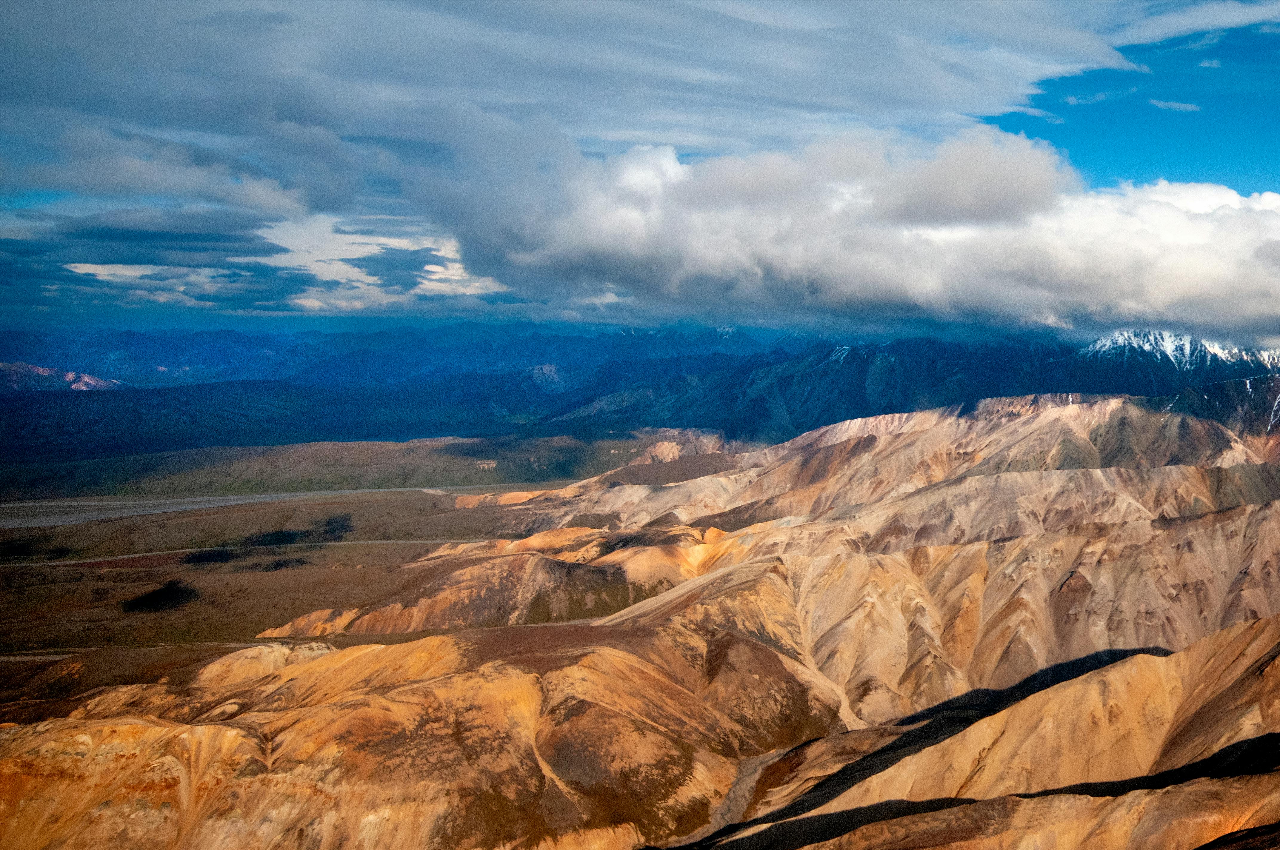 在壮观的天空下，崎岖的山脉呈现出令人惊叹的空中景观