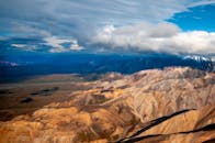 在壮观的天空下，崎岖的山脉呈现出令人惊叹的空中景观
