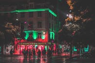 夜晚的城市街景热闹非凡，建筑物灯火通明，人群熙攘