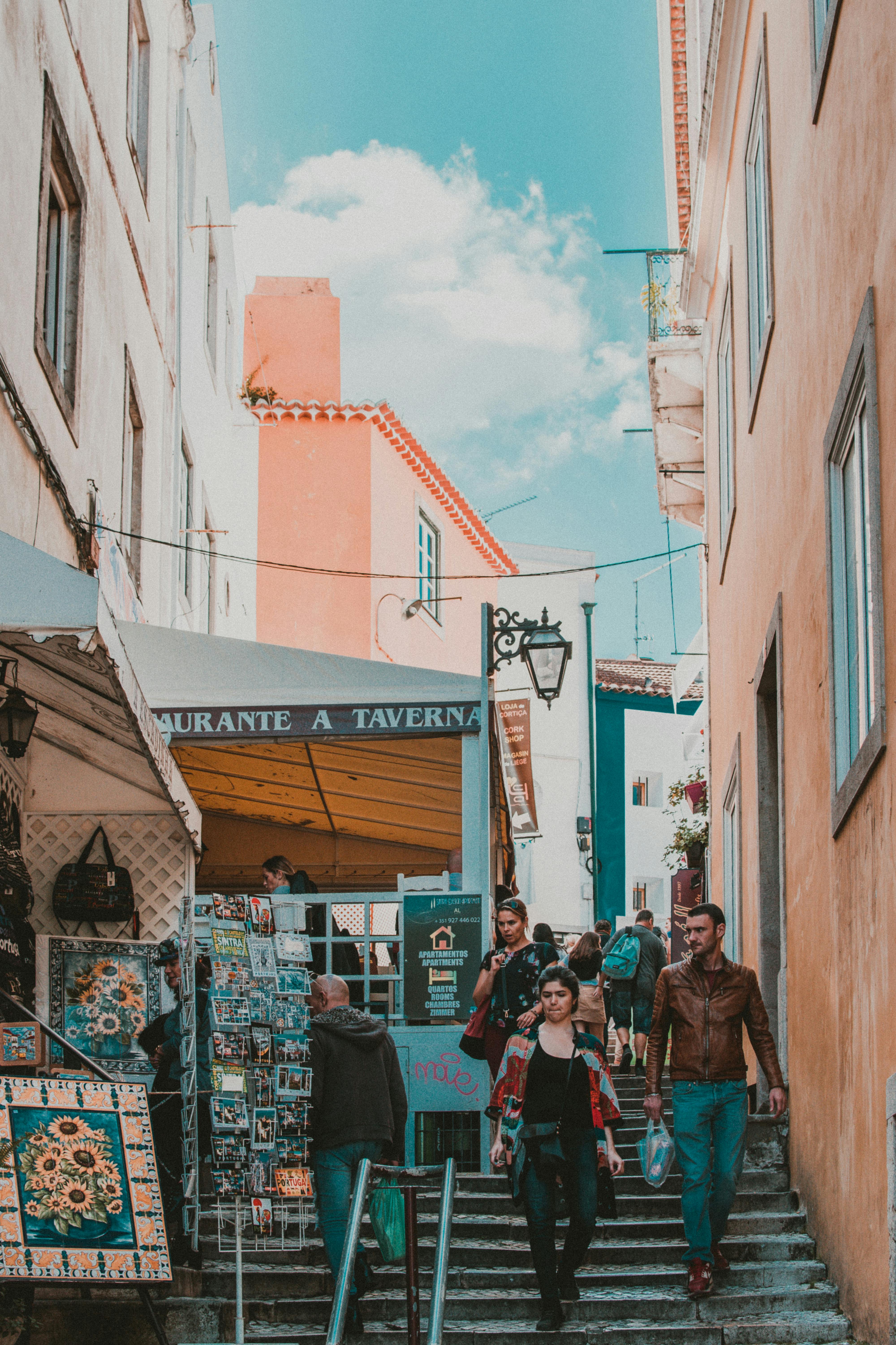 游客们探索欧洲风景如画的小巷，巷子两旁排列着商店和充满活力的建筑