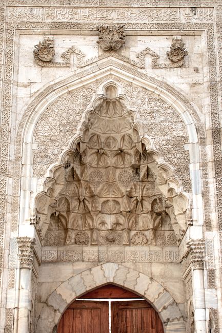 Detailed stone facade with intricate Islamic architectural patterns and arches.