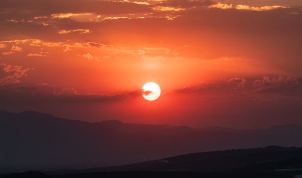 Stunning sunset over the mountains in Irapuato, Mexico, with vibrant red and orange hues.