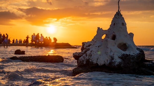 Stunning sunset scene with sand castle and people on the shore of Holbox, Mexico.