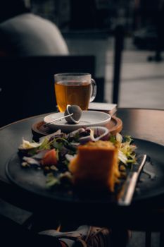 A warm, relaxed breakfast setting in a Polish cafe featuring a salad and tea.