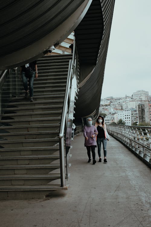 People in Face Masks Walking near Stairs 