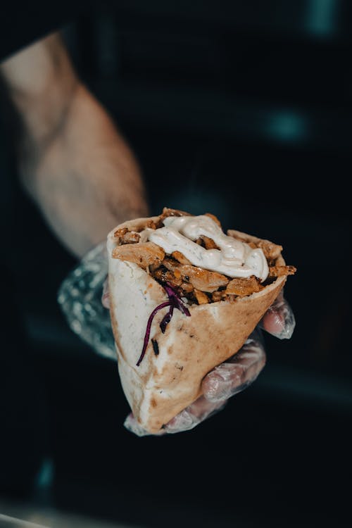 Man Hand Holding Meat in Bread