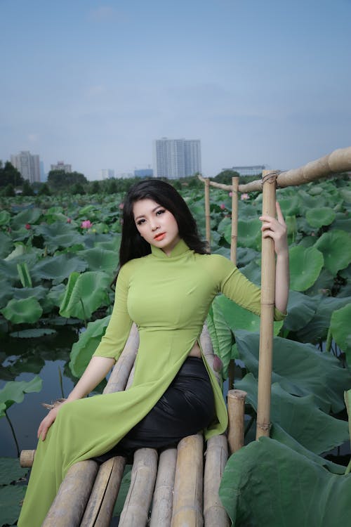 Free Woman Sitting on Brown Bamboo Bridge Stock Photo