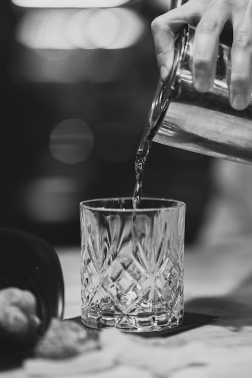 Hand Pouring Water from Pitcher to Glass