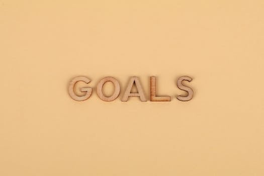 Wooden letters spelling 'GOALS' on a plain background, emphasizing motivation.