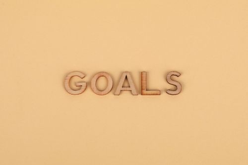 Free Wooden letters spelling 'GOALS' on a plain background, emphasizing motivation. Stock Photo