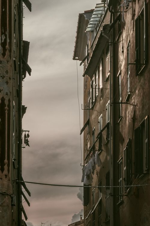 Free Dramatic view of vintage residential buildings with hanging laundry, capturing an urban atmosphere. Stock Photo
