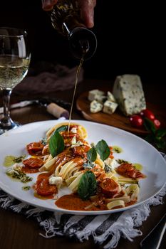 Delicious Italian pasta dish with blue cheese, tomatoes, and a drizzle of olive oil.
