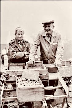 Charming elderly couple selling fresh produce at an outdoor market, captured in a vintage style.