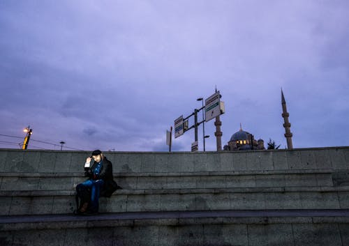Man Sitting with Smartphone on Steps in Istanbul