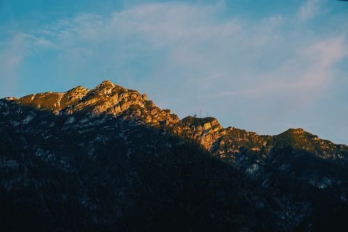 Free Stunning view of a mountain range with golden sunlight and blue sky, captured at sunset. Stock Photo