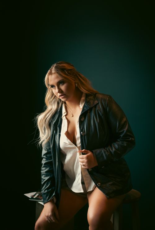 Free A young woman posing in a leather jacket indoors, exuding confidence and style. Stock Photo