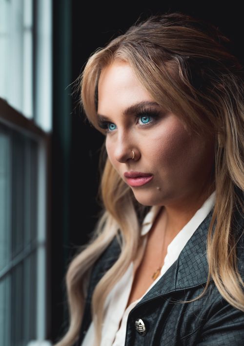 Free Elegant portrait of a young blonde woman in a leather jacket, gazing thoughtfully outside. Stock Photo