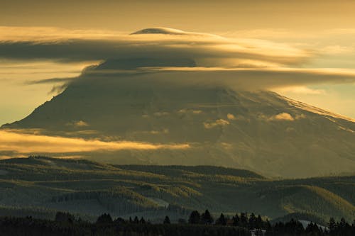 Landscape of a Large Volcano with Clouds around Its Peak and Trees in a Valley 