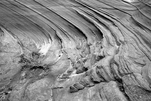 一张令人惊叹的黑白照片，展现了沙漠环境中分层的砂岩地层