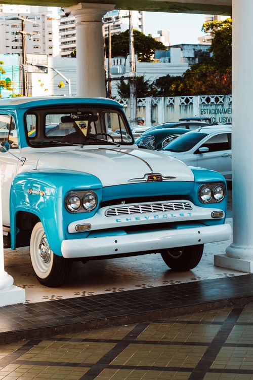 Free Retro Chevrolet truck displayed in a city backdrop, featuring classic blue and white livery. Stock Photo