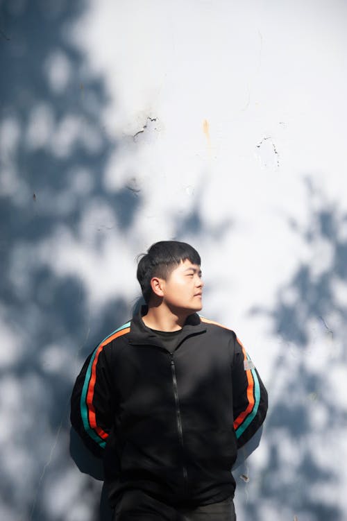 Man Posing by Sunlit Wall